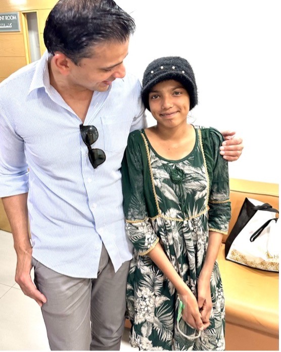 Iqra smiling after recovery with her physician - treatment funded by PSI donors